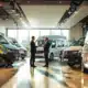 A modern showroom of Van den Hurk Commercial Vehicles with various commercial vehicles, a business meeting and plenty of natural light.