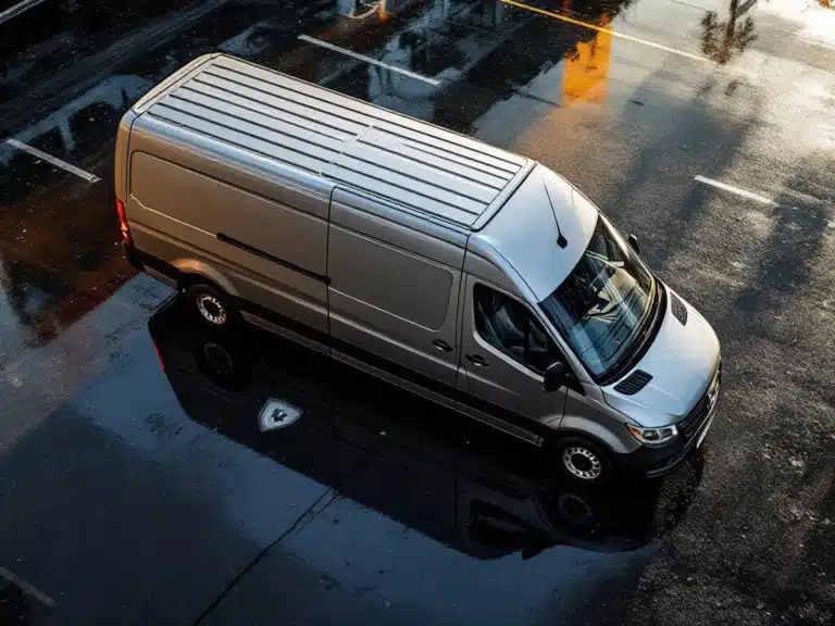 Camionnette moderne à double cabine argentée sur asphalte mouillé avec document d'assurance reflété dans une flaque d'eau