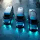 Drie moderne elektrische bedrijfsbusjes in verschillende maten op gepolijst beton met LED-verlichting