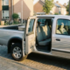 Pick-up a doppia cabina color argento parcheggiato in una soleggiata strada olandese, con le porte posteriori aperte, il sedile posteriore e la cassetta degli attrezzi nel cassone.